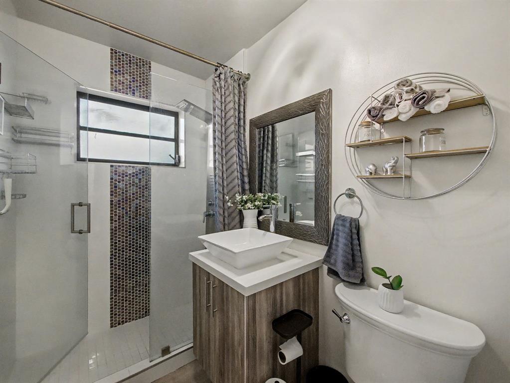 1255 Northwest 63rd Way Margate, FL 33063 - Photo 25 of 33 a bathroom with a toilet a sink and mirror