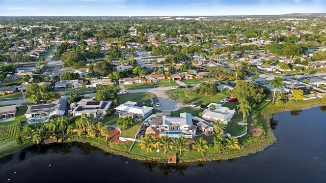 an aerial view of residential houses with outdoor space and trees