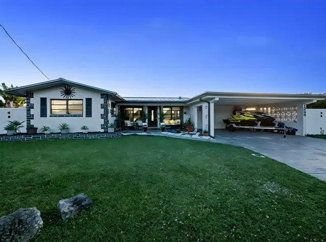 a car parked in front of a house with a yard