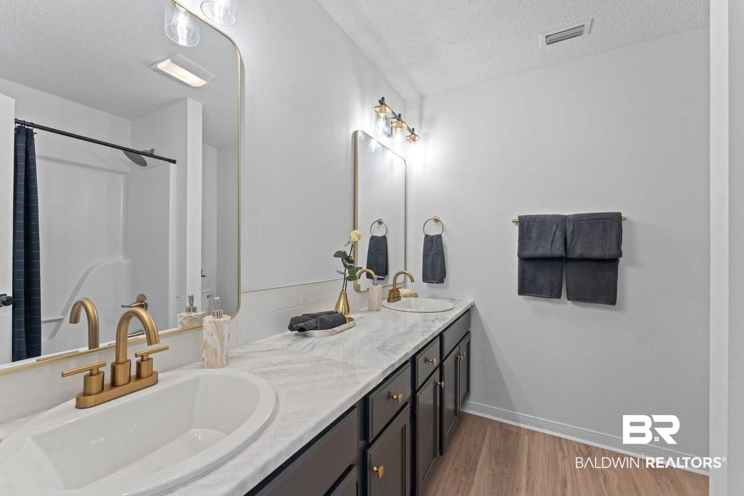 10251 Windmill Road Fairhope, AL 36532 - Photo 36 of 44 Bathroom with a textured ceiling, wood finished floors, double vanity, and a shower with shower curtain