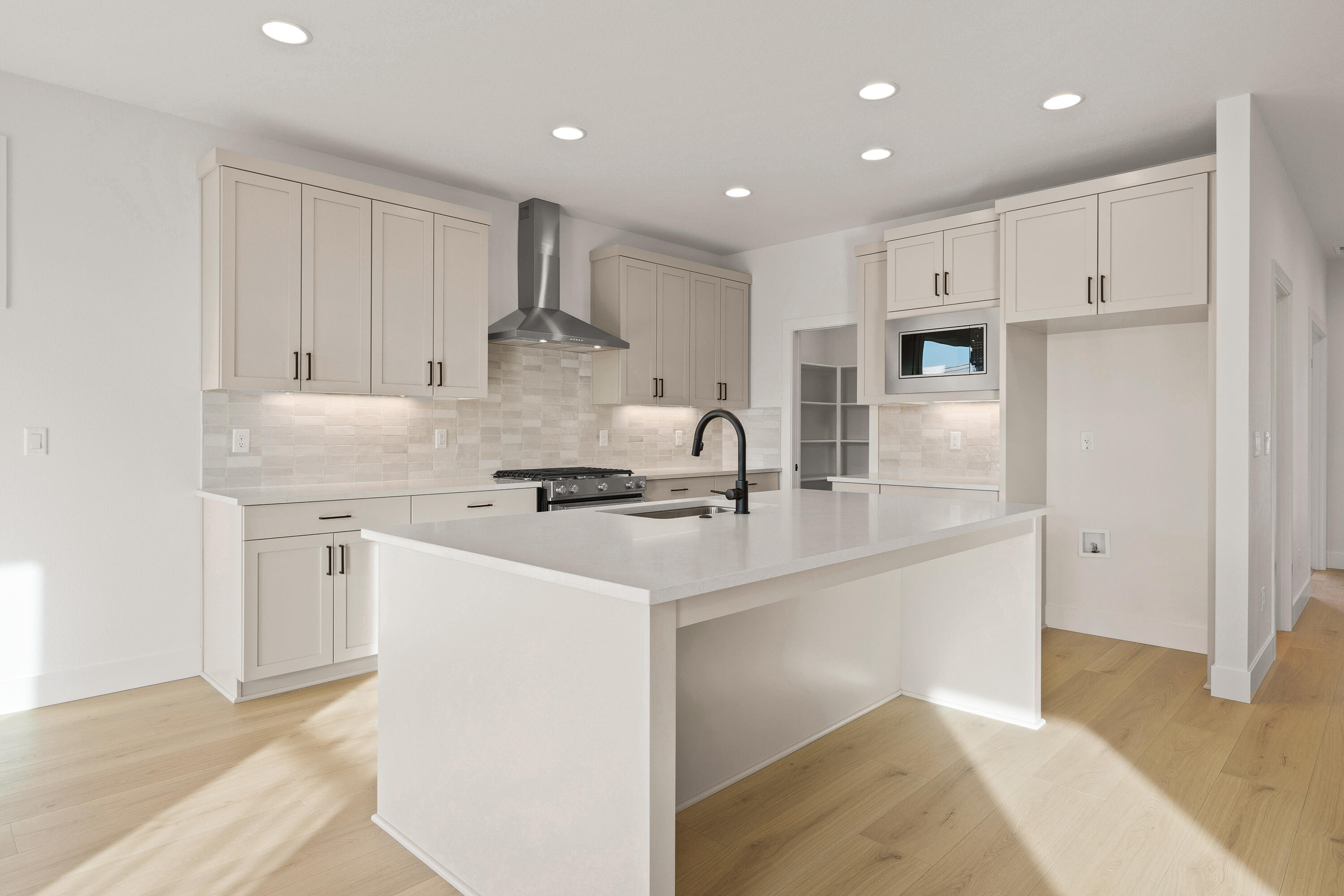 4383 Southwest Rhyolite Place, Unit 22 Redmond, OR 97756 - Photo 15 of 44 a kitchen with kitchen island a sink a stove a refrigerator and white cabinets