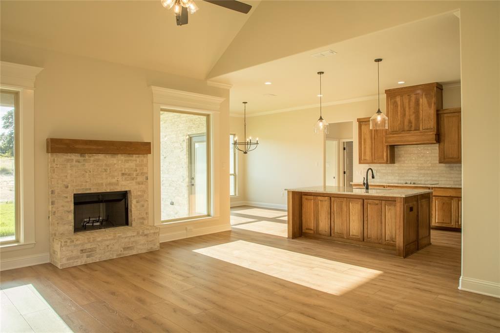 141 Prairie Winds Drive Poolville, TX 76487 - Photo 8 of 15 a large white kitchen with granite countertop a stove a sink and a refrigerator