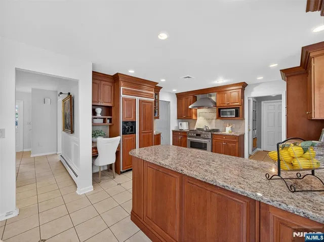 a kitchen with stainless steel appliances granite countertop a refrigerator and a sink