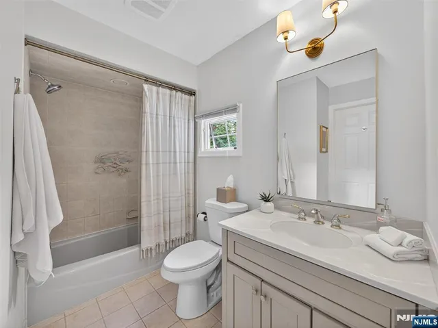a bathroom with a granite countertop sink a toilet and shower