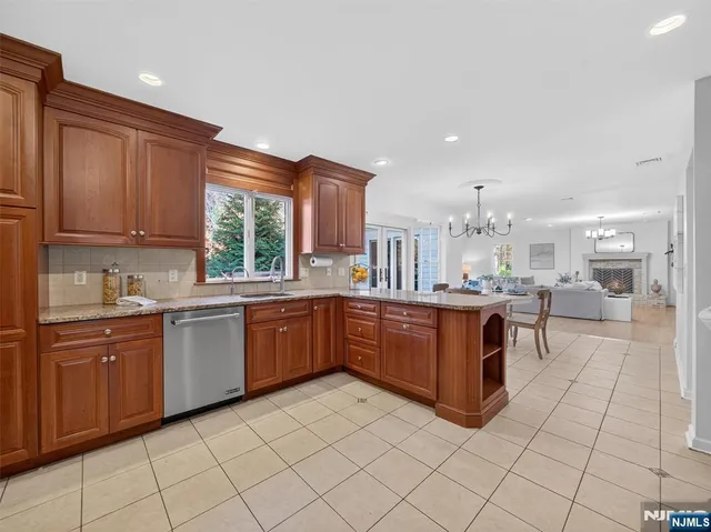 a kitchen with stainless steel appliances granite countertop a stove top oven a sink dishwasher and cabinets