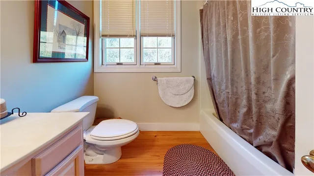 a bathroom with a toilet and a shower curtain