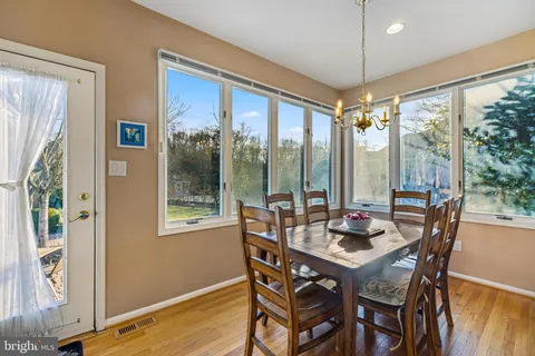 a view of a dining room with furniture large windows and wooden floor