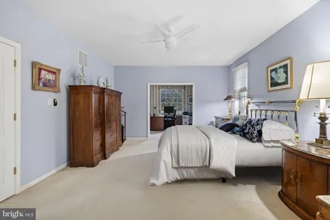 a spacious bedroom with a bed and wooden floor