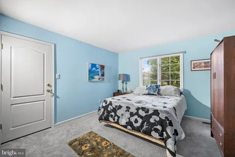 a bedroom with a bed next to a window