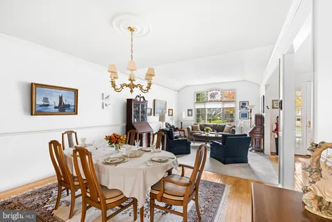 a view of a dining room with furniture a chandelier and wooden floor
