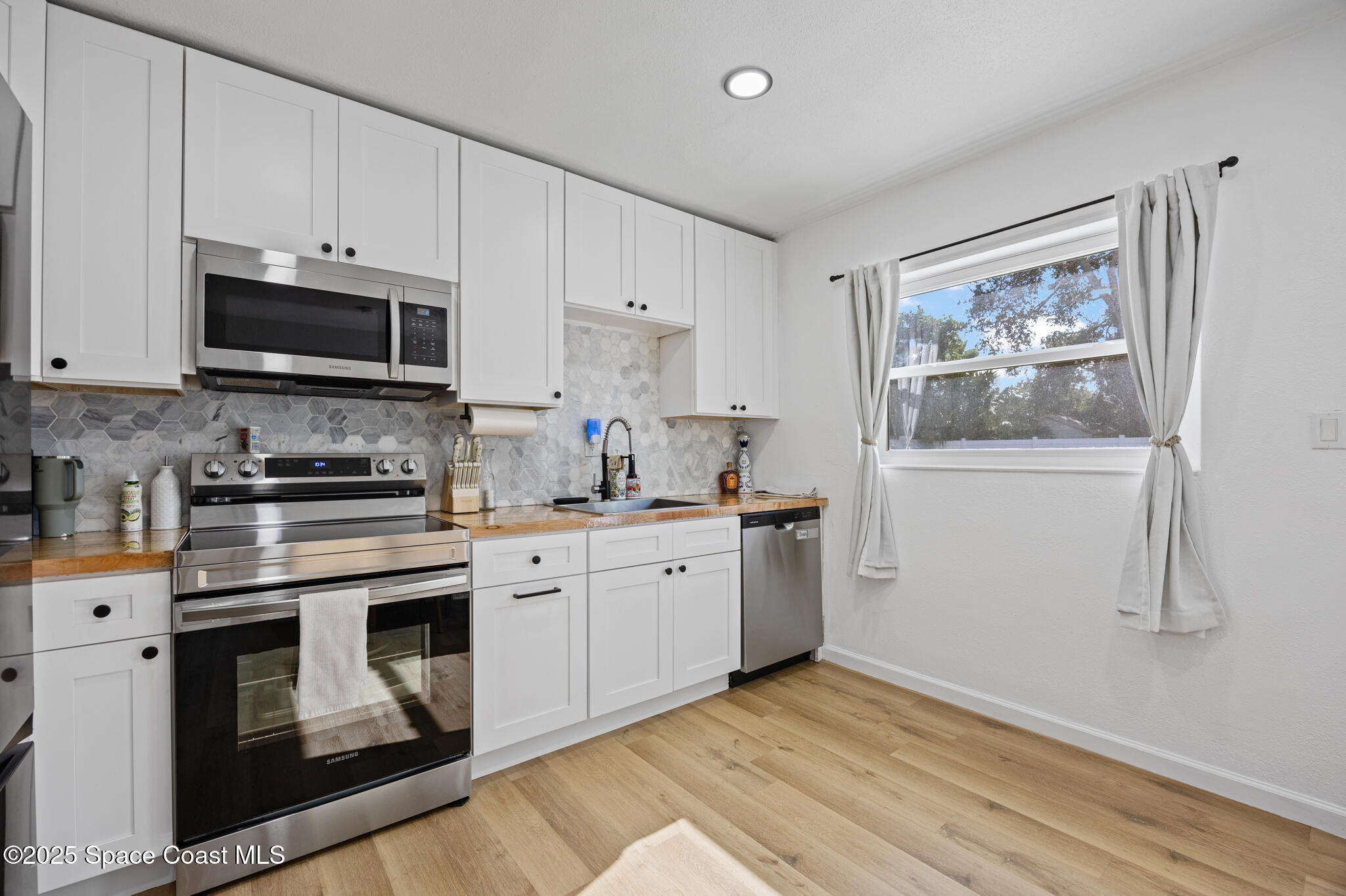 115 Primrose Lane Melbourne, FL 32901 - Photo 16 of 22 a kitchen with granite countertop white cabinets and white appliances