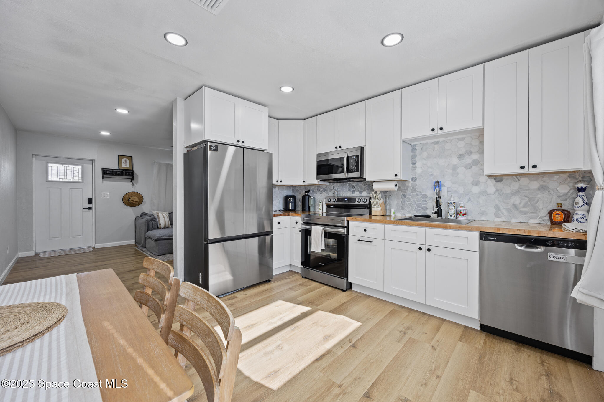 115 Primrose Lane Melbourne, FL 32901 - Photo 2 of 22 a kitchen that has a refrigerator a sink and a stove top oven
