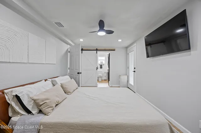 a bedroom with a bed and a flat screen tv