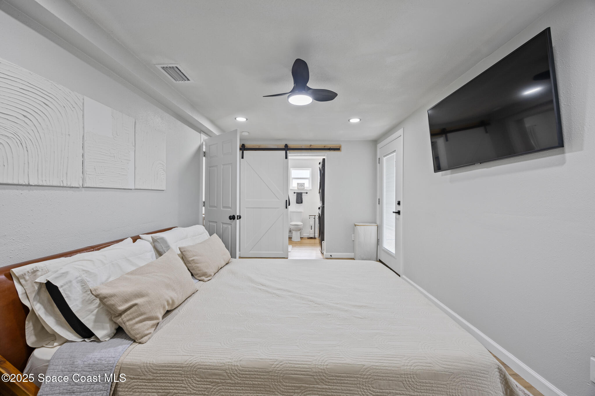 115 Primrose Lane Melbourne, FL 32901 - Photo 3 of 22 a bedroom with a bed and a flat screen tv