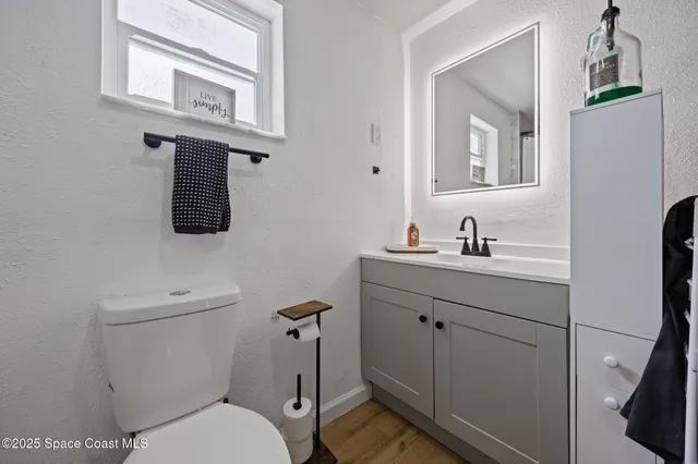 a bathroom with a toilet sink and mirror