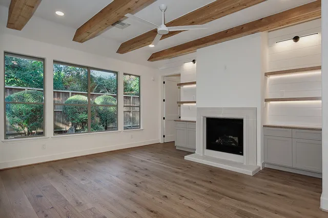 a view of an empty room with a fireplace and a window