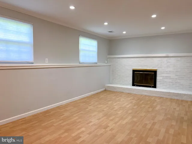 a view of empty room with wooden floor and fireplace