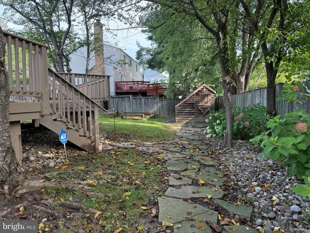 a view of house with outdoor space swimming pool and trees in the background