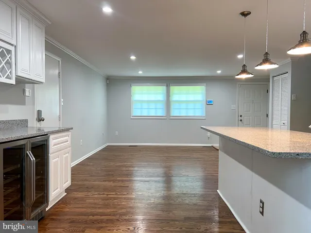a view of a kitchen with kitchen island a sink wooden floor and a fireplace