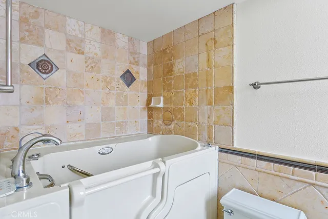 a bathroom with a granite countertop sink and a bathtub