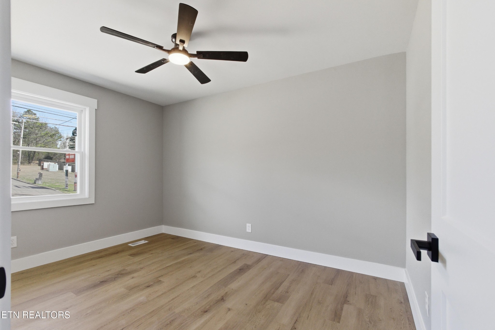 2241 Woods-Smith Road Knoxville, TN 37921 - Photo 22 of 37 an empty room with wooden floor ceiling fan and windows