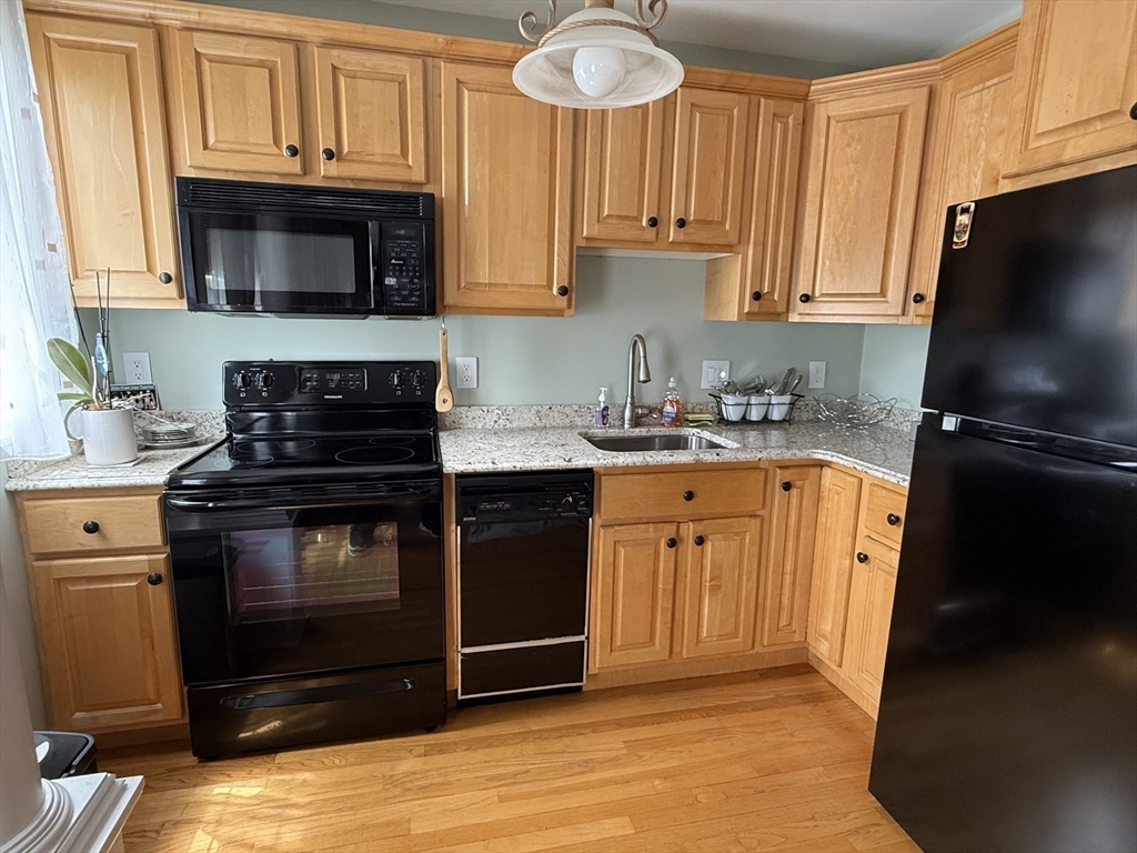 5 Porter Road, Unit 202 Andover, MA 01810 - Photo 3 of 17 a kitchen with stainless steel appliances granite countertop a stove microwave and sink
