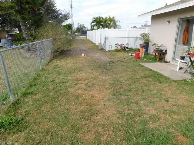 a backyard of a house with table and chairs