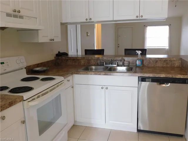 a kitchen with granite countertop white cabinets and white appliances