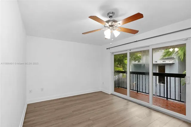 a view of a room with wooden floor chandelier fan and windows