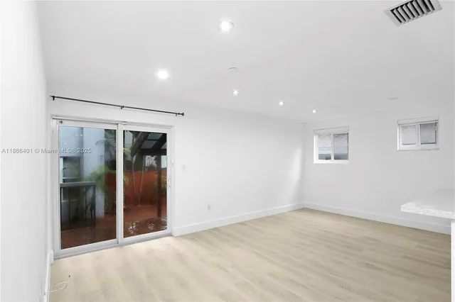 an empty room with closet and windows