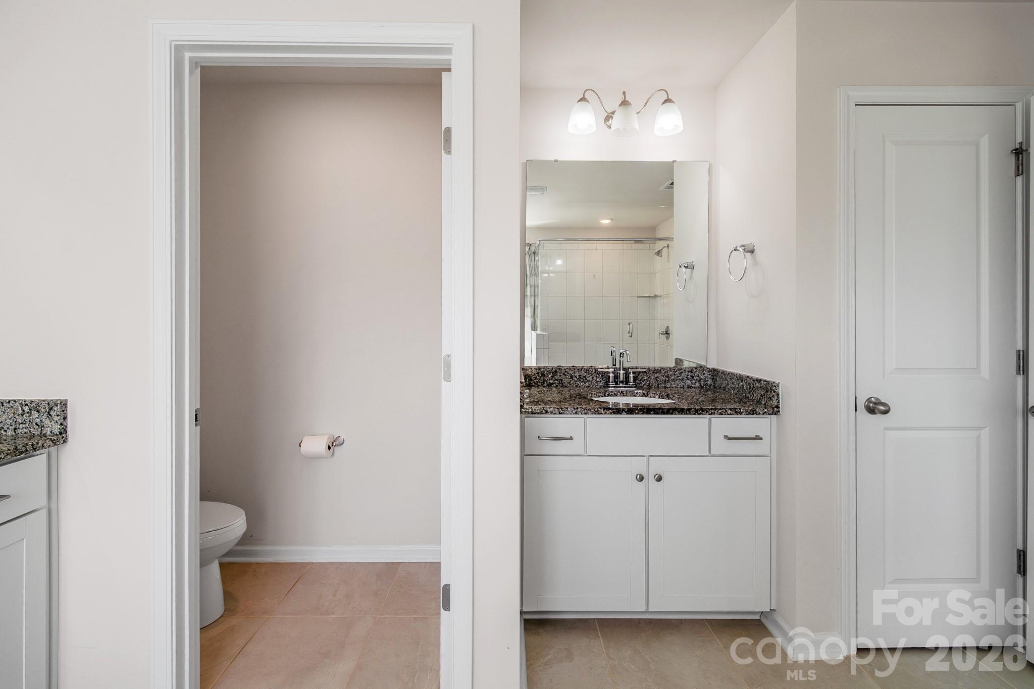 1630 Fitzgerald Street Northwest Concord, NC 28027 - Photo 22 of 38 a bathroom with a granite countertop sink and a mirror