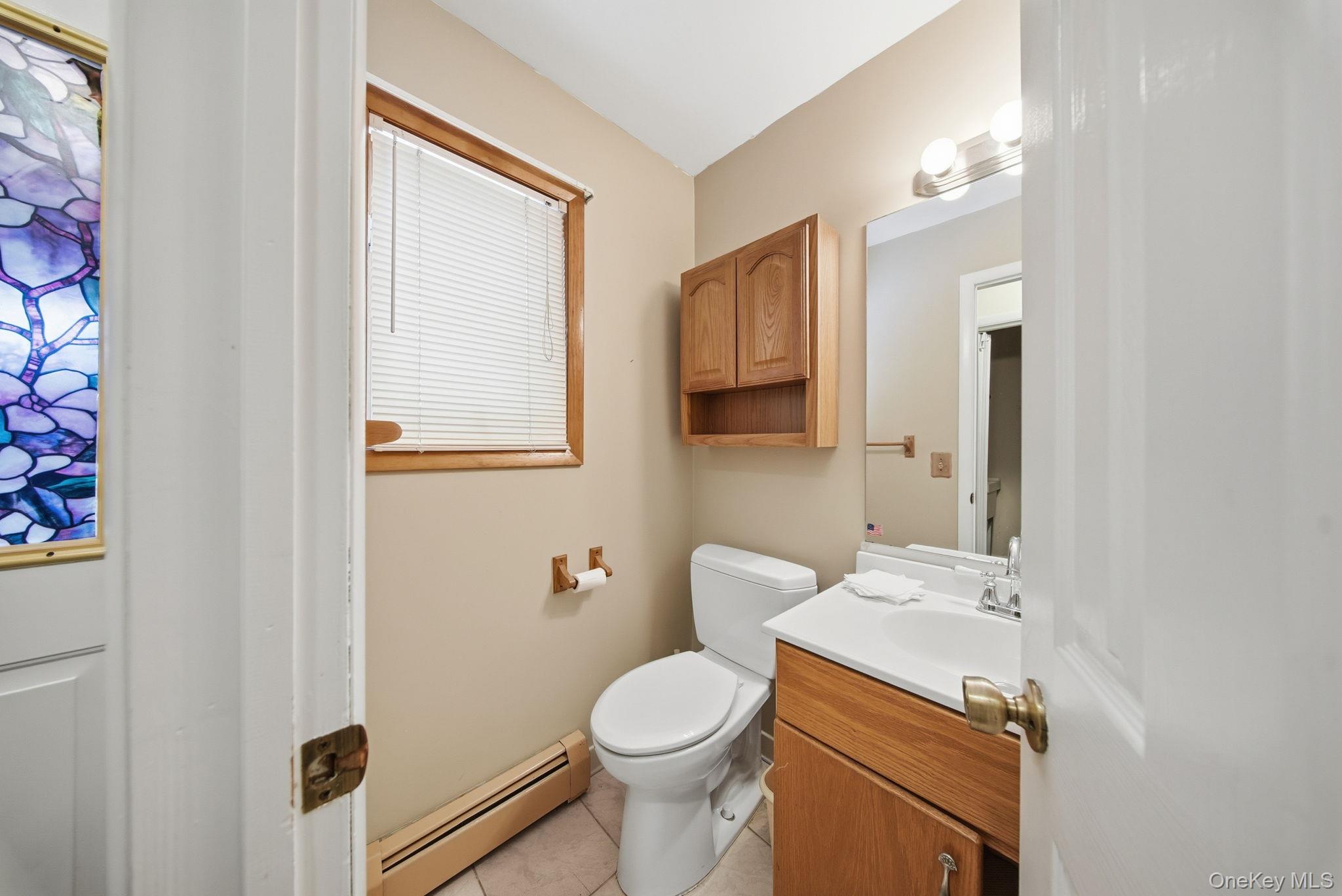139 Renner Road Mountain Dale, NY 12763 - Photo 18 of 49 Half bathroom with baseboard heating, vanity, and light tile patterned flooring