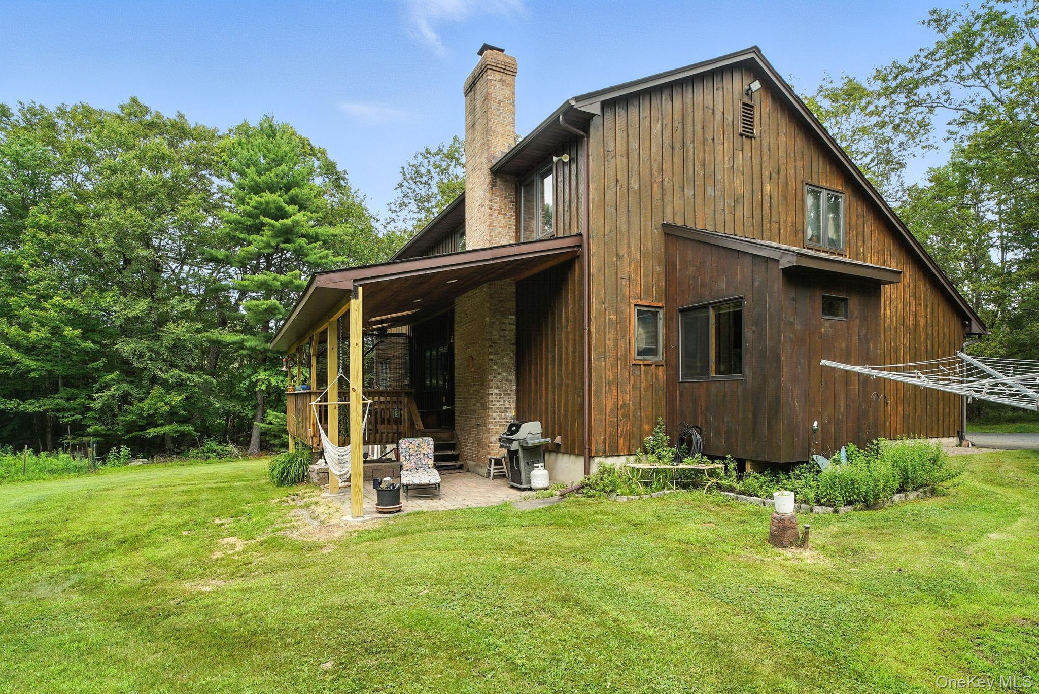 139 Renner Road Mountain Dale, NY 12763 - Photo 47 of 50 Back of property featuring a chimney, a lawn, and a patio