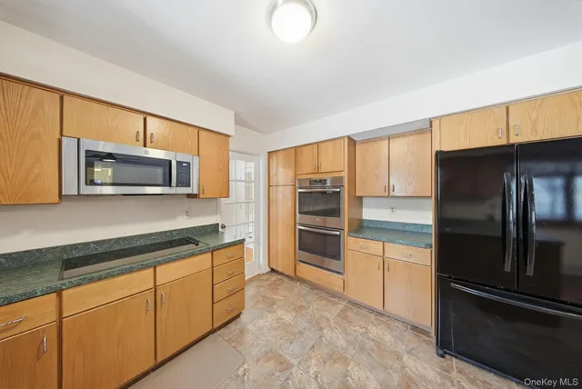 a kitchen with stainless steel appliances granite countertop a stove a sink and a refrigerator