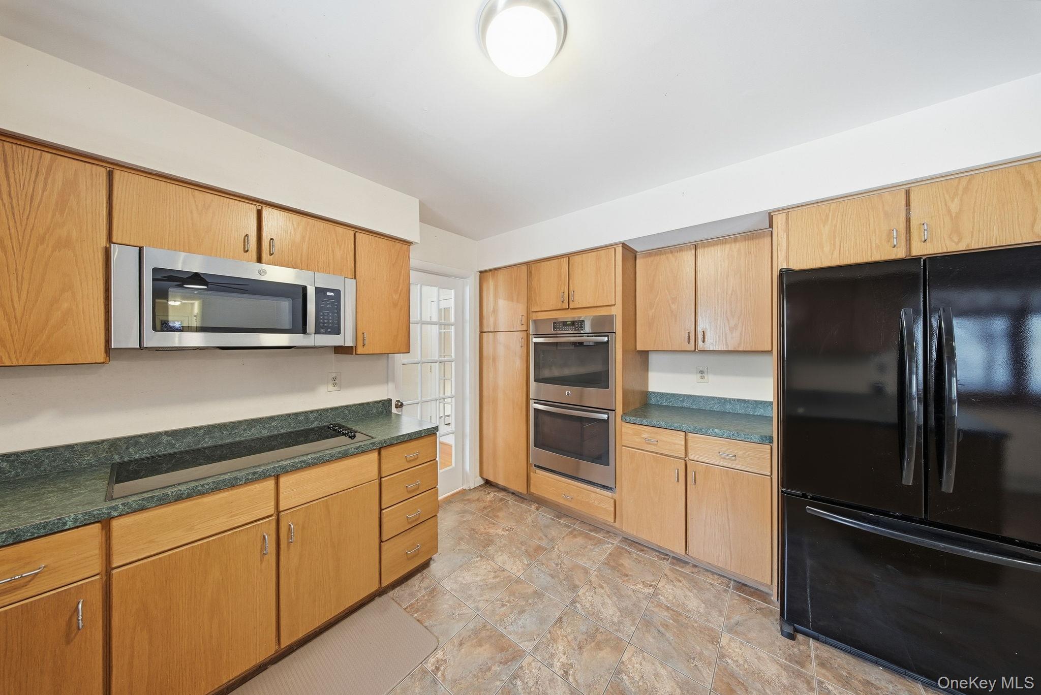 139 Renner Road Mountain Dale, NY 12763 - Photo 10 of 49 Kitchen with black appliances, dark countertops, stone finish flooring, and brown cabinetry