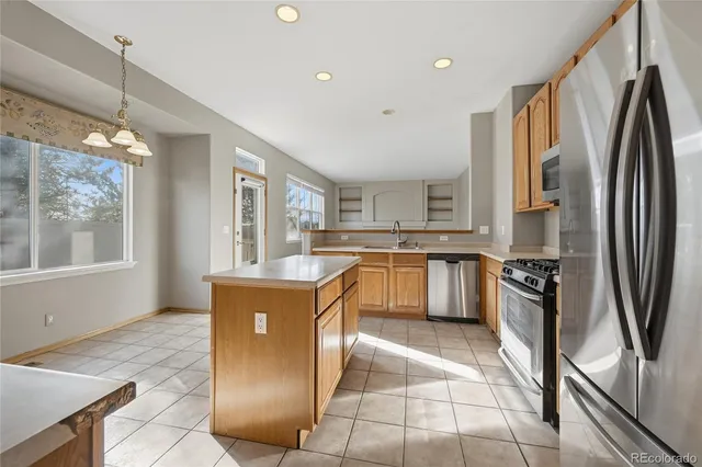 a kitchen with a refrigerator a stove top oven and a sink