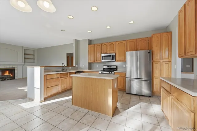 a kitchen with stainless steel appliances granite countertop a stove top oven a sink dishwasher and a refrigerator