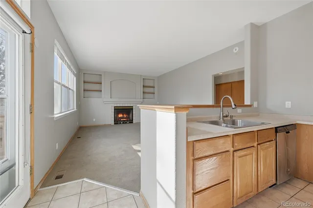 a view of an empty room with a fireplace and a window