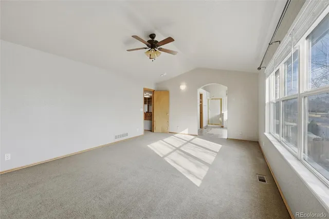 a large white bathroom with a granite countertop sink a toilet a mirror and bathtub
