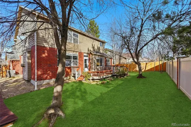 a view of a house with backyard and a tree