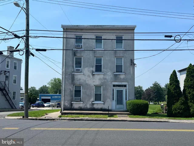 a view of a brick building next to a yard