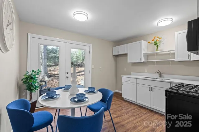 a kitchen with stainless steel appliances kitchen island granite countertop a sink a stove a dining table and chairs