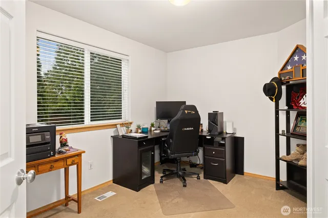 a view of a workspace with furniture and a window