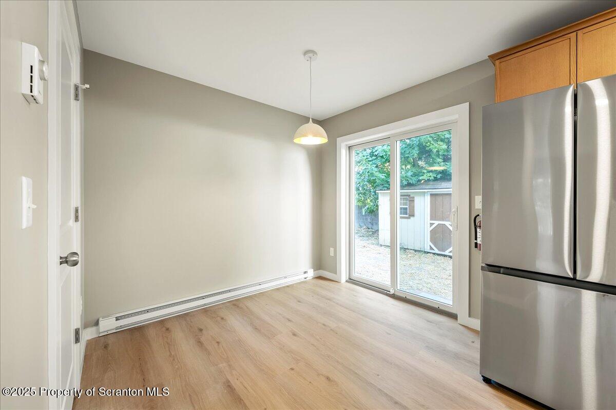 820 822 Delaware Street Scranton, PA 18509 - Photo 10 of 48 a view of a kitchen with a refrigerator a ceiling fan and wooden floor