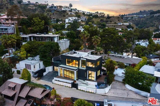 an aerial view of multiple houses with a yard