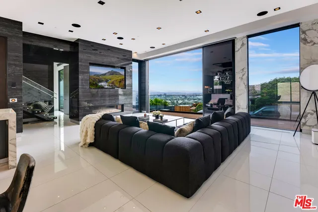 a living room with fireplace furniture and a large window
