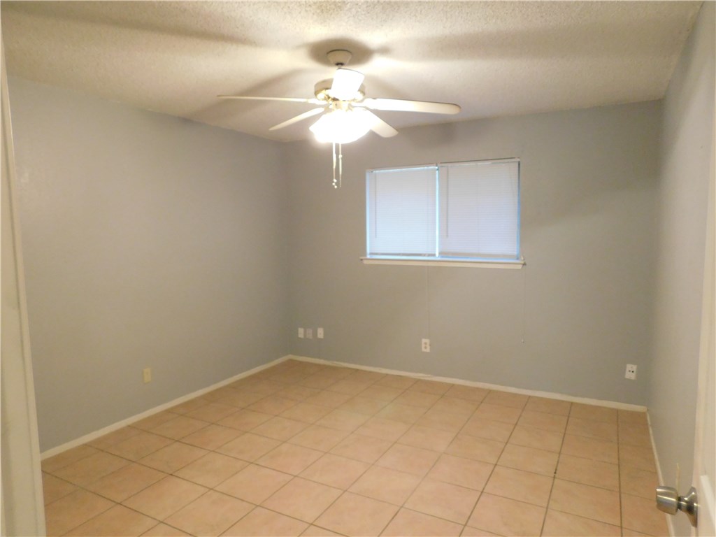 1402 Barbergale Street, Unit A Pflugerville, TX 78660 - Photo 8 of 15 en empty room with windows and chandelier fan