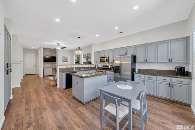 a kitchen with kitchen island granite countertop a sink cabinets and wooden floor