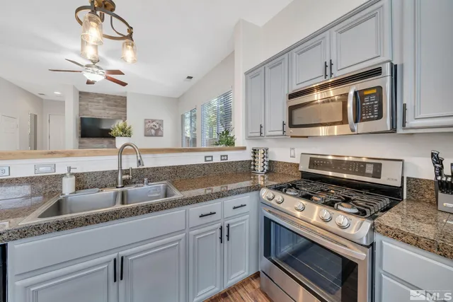 a kitchen with a sink a refrigerator and wooden floor