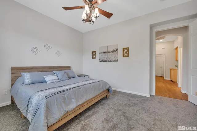 a spacious bedroom with a large bed a chandelier and a window
